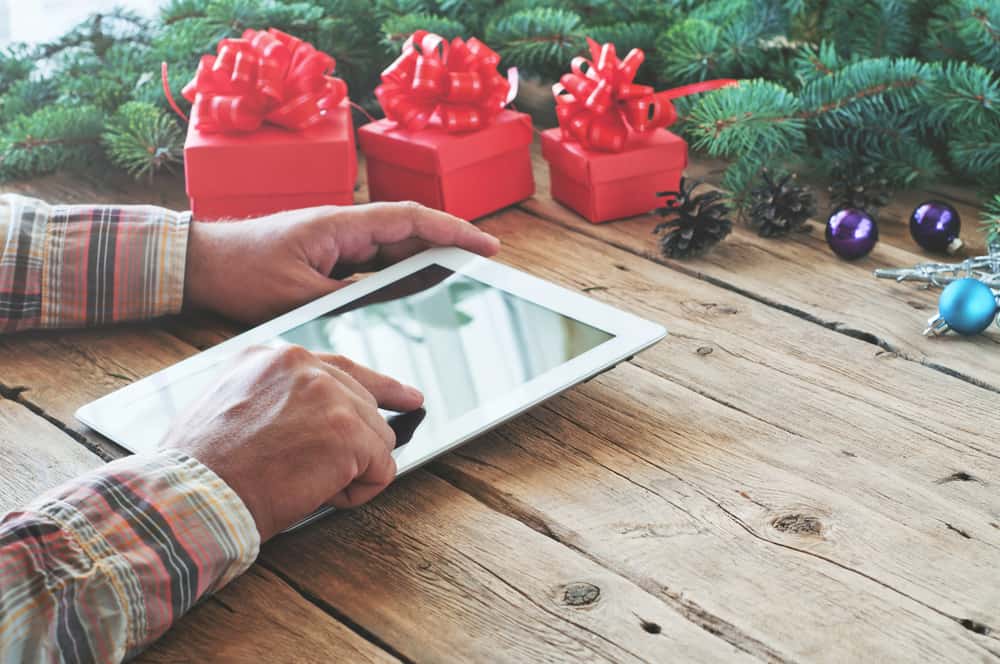 A man uses his iPad to order holiday gifts.